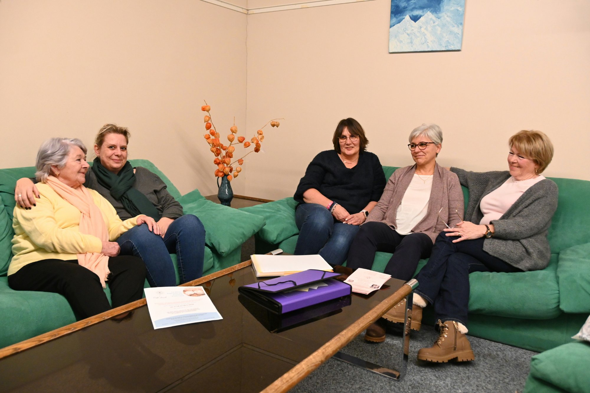 Groupe réuni pour une rencontre du Café-deuil, assis sur des canapés verts dans un espace chaleureux